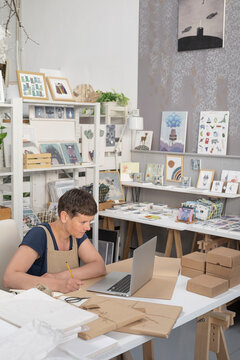 Successful Artist Focused On Computer In Atelier