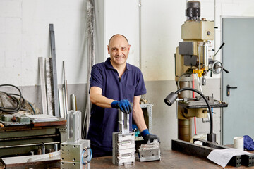 Smiling mechanic in workshop at factory