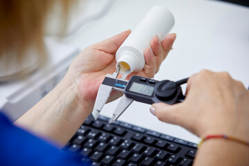 Crop worker measuring bottle with caliper