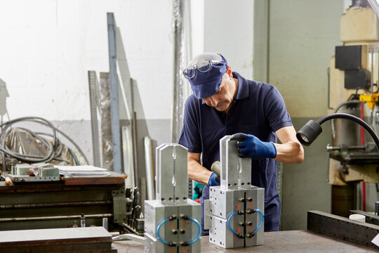 Male mechanic repairing plastic bottles molds