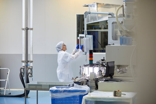Focused employee operating modern industrial machine