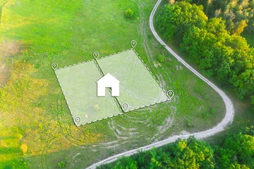Fotobehang Land Plot for Housing on green field - aerial drone shot. Topographical Marking of two plots of Land for Private Residence House Construction. Land Plot plan with white Graphic House icon. © Andrii Chagovets
