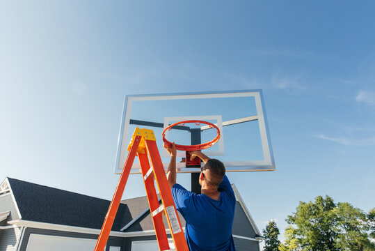 Man assembling basketball post. 