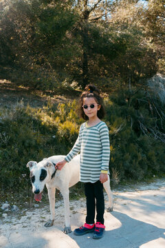 Kid and dog taking posing outdoors 