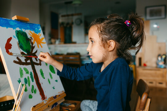 Kid painting on canvas at home