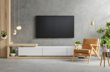Cabinet TV in modern living room with armchair,lamp,table,flower and plant on concrete wall background.