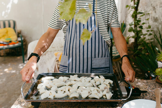 Unrecognizable man's hands holding griddle outdoor
