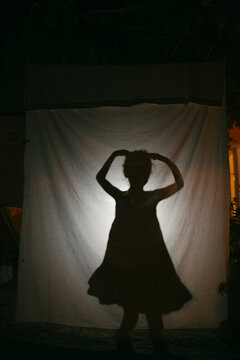 Kid doing Shadow play in country-house at night