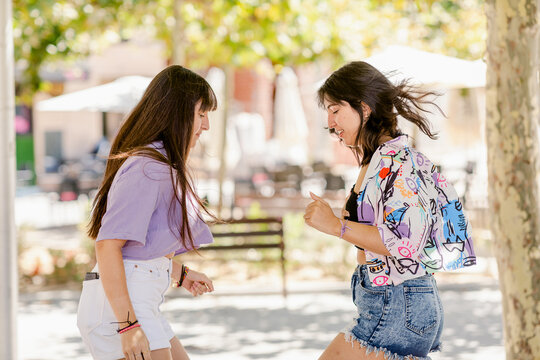 Teenager sisters dancing at urban park