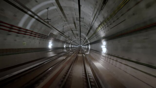 View of moving train in subway tunnel from forward window. Fast riding metro in modern city. Long footage of underground carriage following its route.