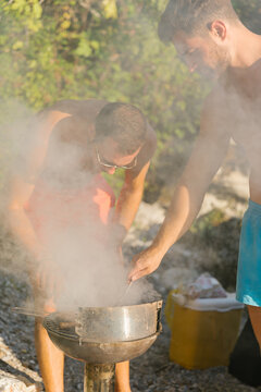 Friends preparing barbecue at the beach