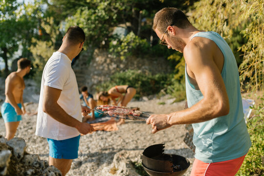 Friends preparing barbecue at the beach