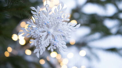 Christmas tree. Christmas tree with a snowflake Christmas toy, with a garland in the background. New Year's card. © Наталья некрасова