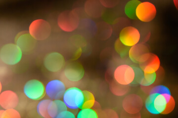Fototapeta premium Abstract colorful glowing iridescent drops and sparkles on a brown background. Rainbow bokeh backdrop or overlay. Blurred defocused circles.