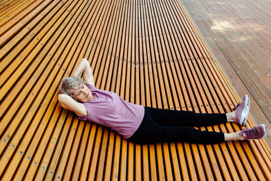 Senior woman in sportswear resting on bench
