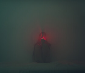 Hand covering a light coming from the mouth