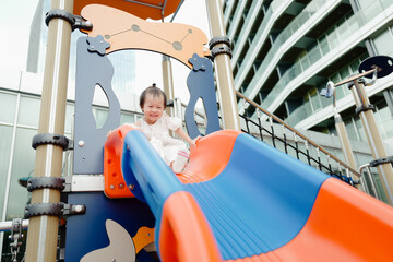 Asian baby playing happily on the slide