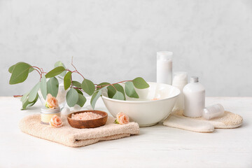 Spa set with bowl of water on light background