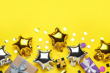 Beautiful balloons and gift boxes on yellow background