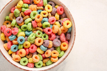 Bowl of colorful cereal rings on light background