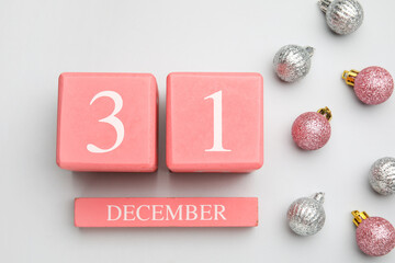 Calendar with date of New Year and Christmas balls on white background