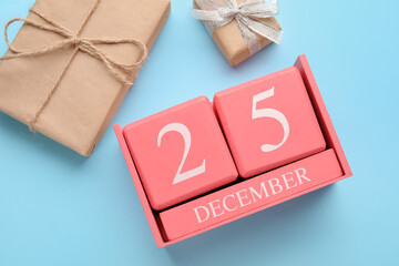 Calendar with date of Christmas and gift boxes on blue background