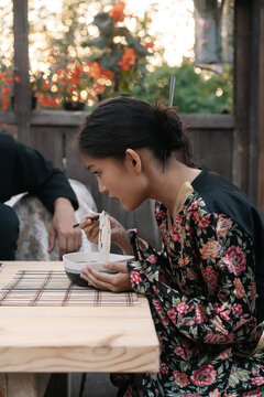 Beautiful woman in kimono dines noodles in restaurant
