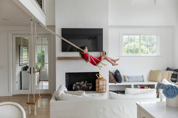 Side view of Child on Swing indoors at home