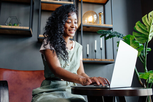 Black woman typing notes on laptop