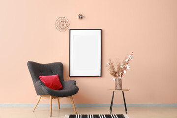 Interior of stylish room with dark armchair and blank poster