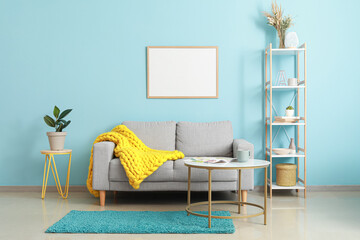 Interior of modern living room with sofa, bookshelf and blank poster