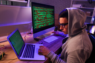 Fototapeta na wymiar Hacker using computer in dark room