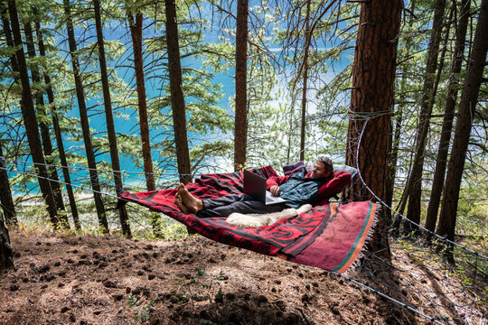 Man working remotely from Hammock in Nature