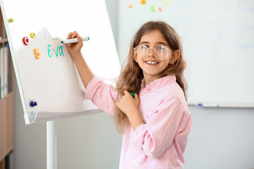 Pupil writing on blackboard during lesson at language school