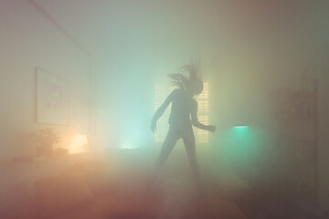 Happy woman dancing on the sofa