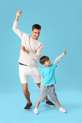 Fototapeta na wymiar Dancing man and his little son on color background