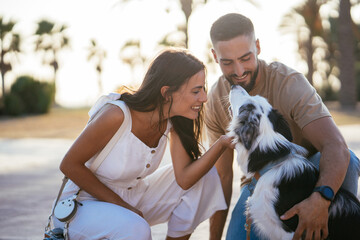Loving couple with loyal dog in park