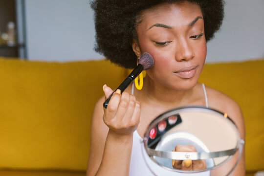 Black Woman Applying blush And Doing Makeup