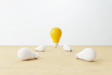Möbelaufkleber Light bulb yellow floating outstanding among white lightbulb on wood table. Concept of creative idea and innovation, Unique, Think different, Individual and standing out from the crowd. 3d render © Monster Ztudio