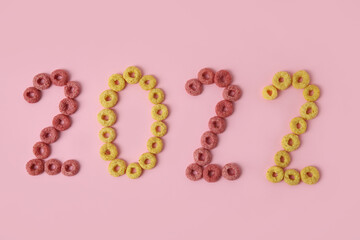 Figure 2022 made of cereal rings on color background, closeup