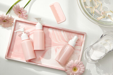 Top view of cosmetic jar in white bathroom with glassware and flower for cosmetic advertising , lifestyle content