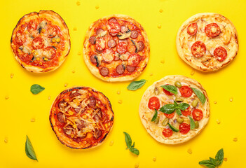 Delicious mini pizzas on yellow background