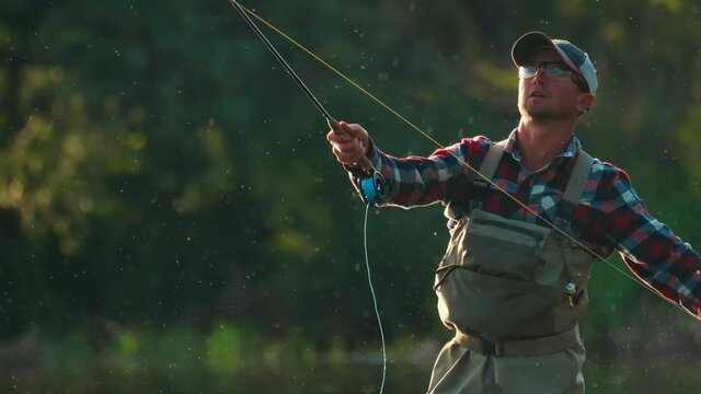 Fly fishing. Man fly fishing on the wild river with lots of insects flying in the air