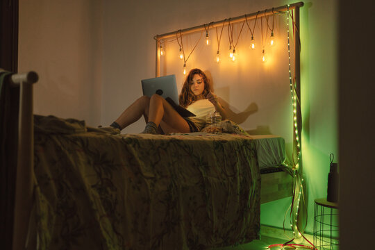 Female with the laptop on the bed