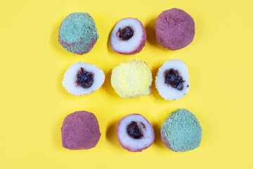 Korean traditional sweet colorful rice tteok snacks isolate on yellow background, top view.
