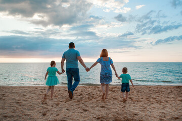 vacation at sea. A family walks along the beach. family holding hands