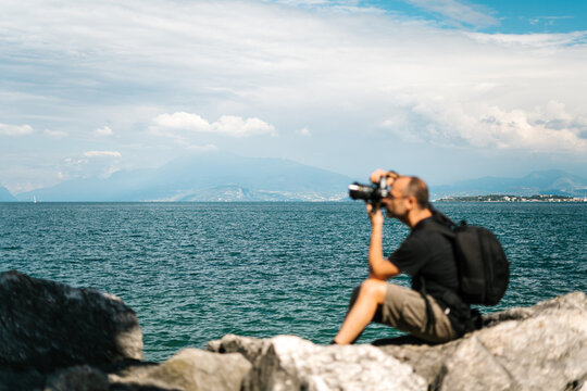 Man taking photo on rocky seacoast