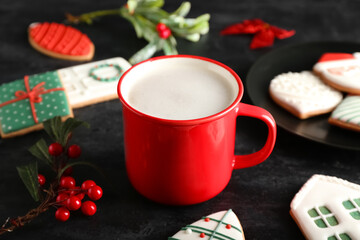 Cup with tasty cocoa and beautiful Christmas cookies on dark background