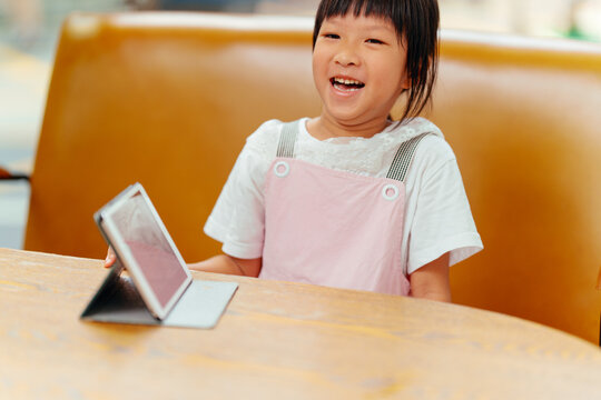 Asian little girl uses a tablet pc