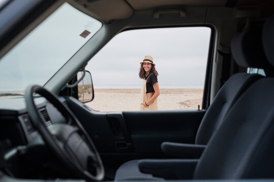 Smiling traveler outside her camper van